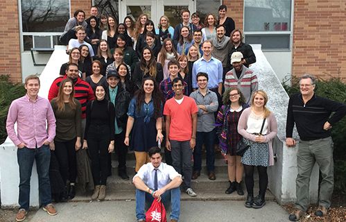 students and faculty pose for picture on the stairs at kresge art center