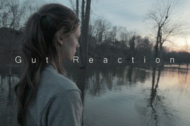 gut reaction movie poster: woman looking out into the distance over water and trees
