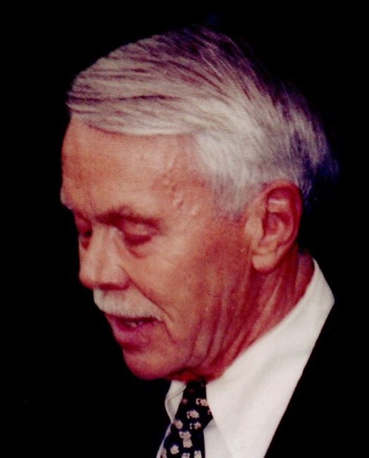 Man with gray hair wearing a white shirt and black blazer