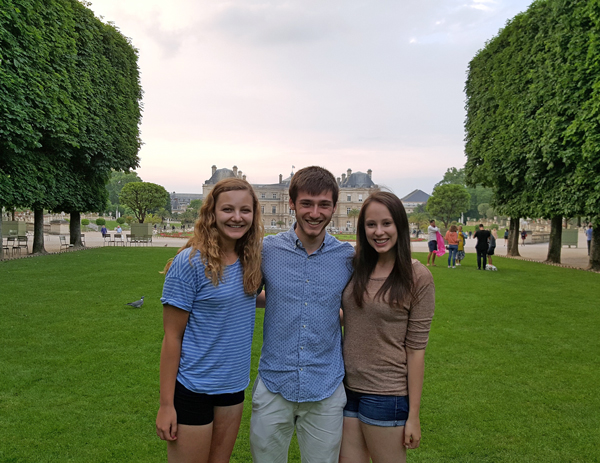 man posing for picture with 2 women in paris