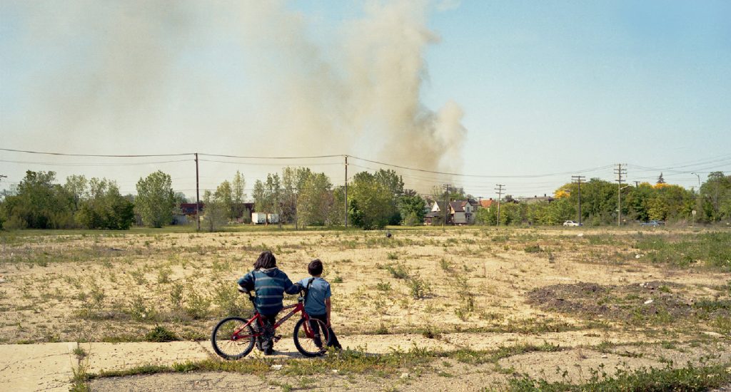 two children with bike in empty field