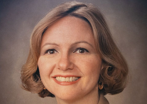 Headshot of a woman with short blonde hair and brown eyes