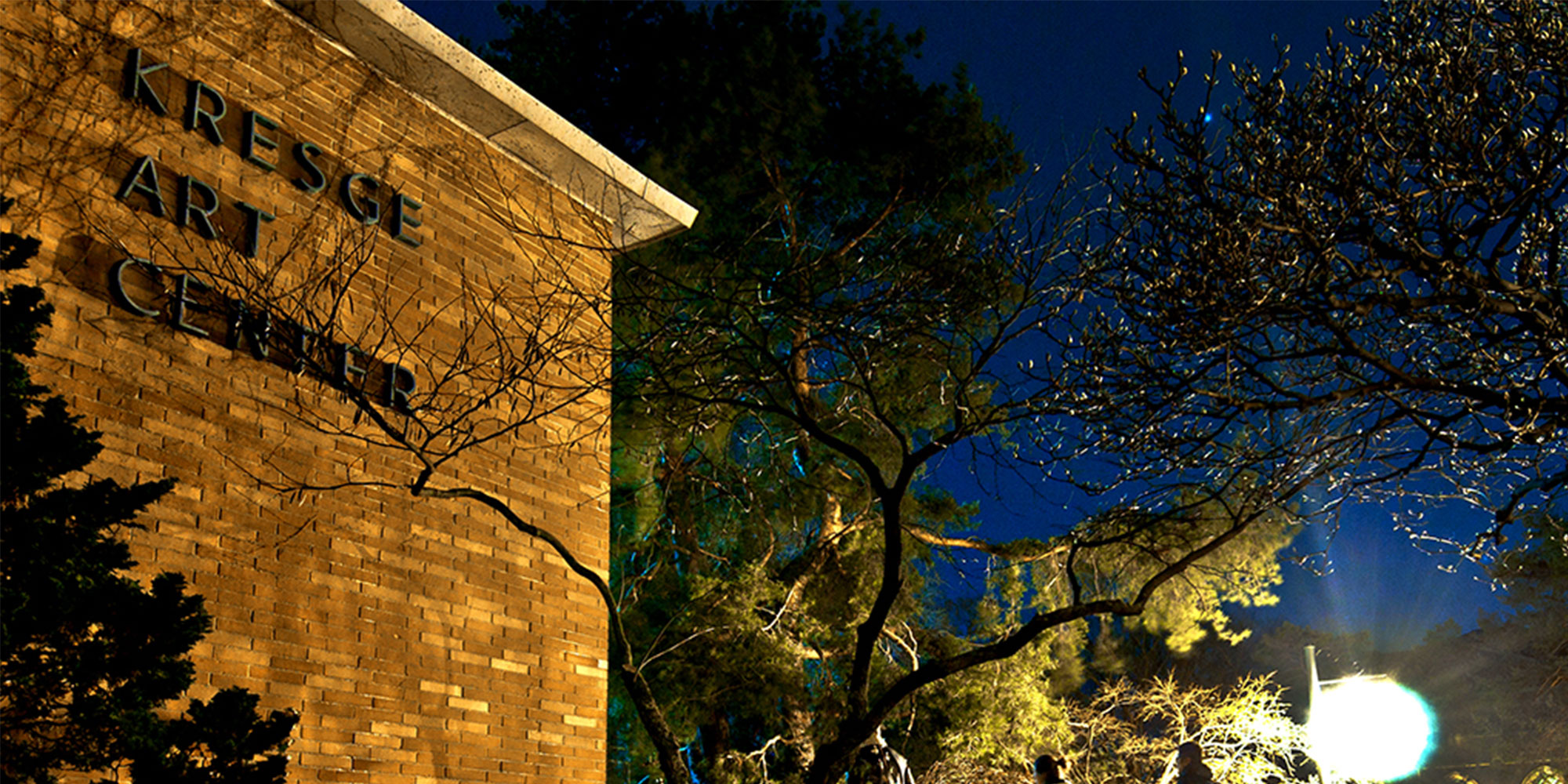 image of red brick building at night, there is lettering on the building that says 'kresge art center'
