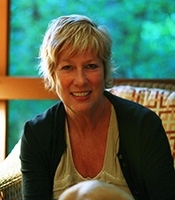 a women with short hair wearing a white shirt and a black cardigan 