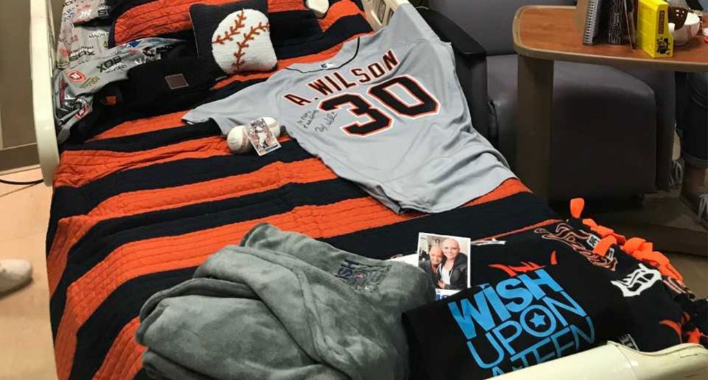 A bed covered in Detroit Tigers gear, photos and items for the Make a Wish Foundation