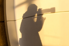 a shadow on a man taking a photo