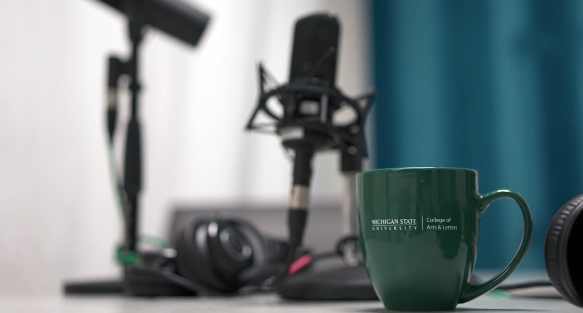 Microphone with Michigan State University mug sitting on table