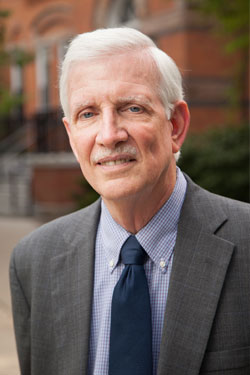 portrait of a man with white hair and blue eyes outside of linton hall