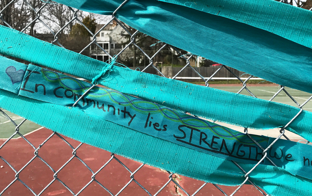 Close-up photo of the fabric that reads: "In community lies strength."