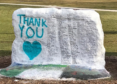 Large rock painted white with a list of names next to the words "thank you" in teal
