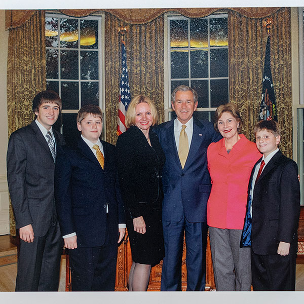 a family standing with George W. Bush and First Lady Laura Bush