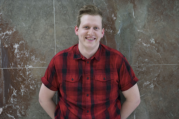 a man wearing a red and black checkered button down 