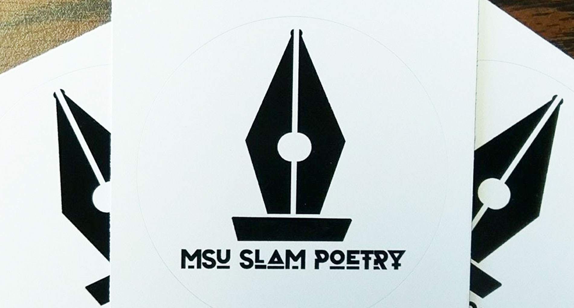 black vintage pen tip graphic with MSU Slam Poetry underneath