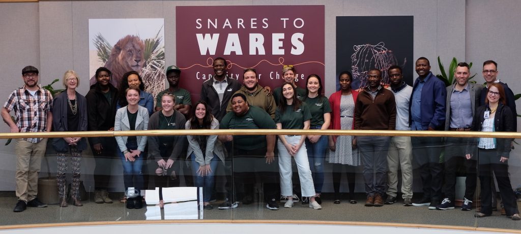 group of people standing close to one another in front of a sign that says 'snares to wares'