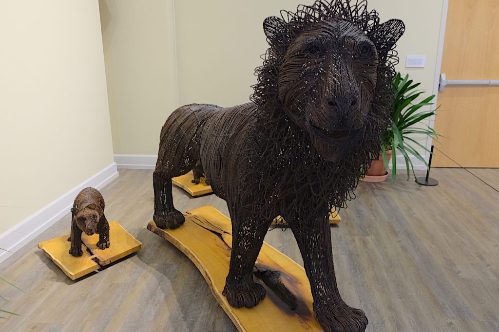 picture of a wire sculpture of a lion next to a small sculpture of a bear