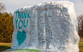 msu rock painted white with teal "thank you" and heart and black signatures