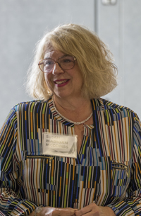 a women with blonde hair wearing glasses and a stripped shirt 