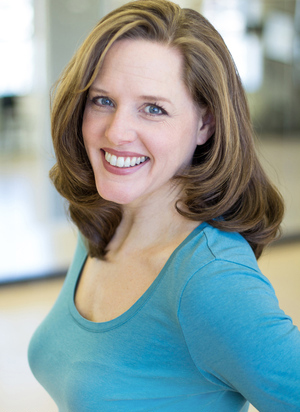 a woman with brown hair wearing a light blue long sleeve shirt