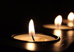 four lit candles in a row