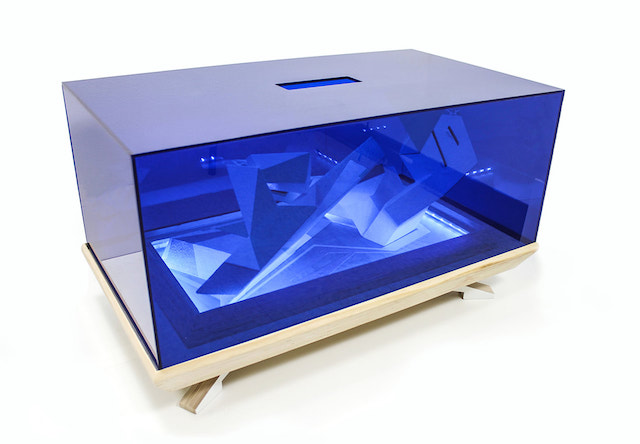an art piece in a clear box, there is a blue lighting