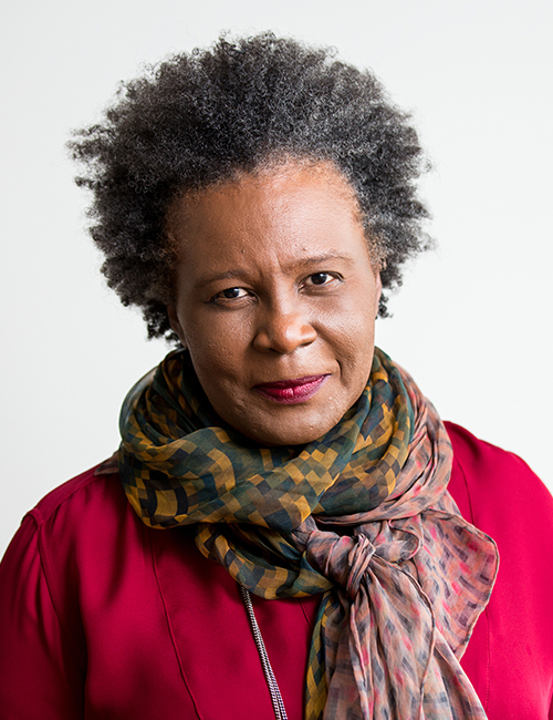 Claudia Rankine in a pink blouse with brightly patterned scarf over it