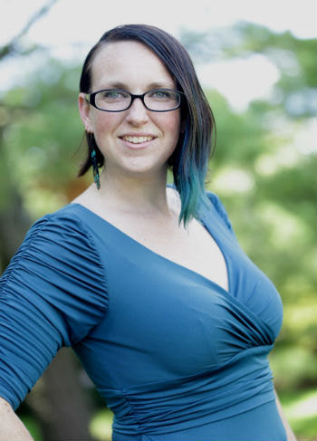 woman wearing glasses and blue dress smiling at the camera