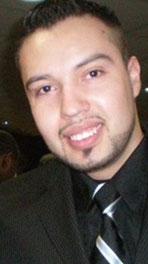 man wearing a black suit smiling at the camera