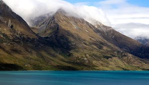 Photo of a lake with mountains covered by clouds