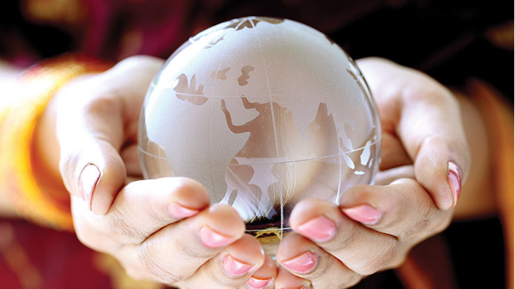 someone holding a glass globe of the world
