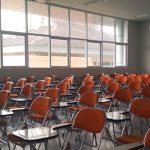 an empty classroom with desk chairs