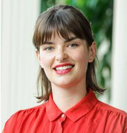 headshot of a woman with shoulder-length hair and bangs. she is wearing a red button-up