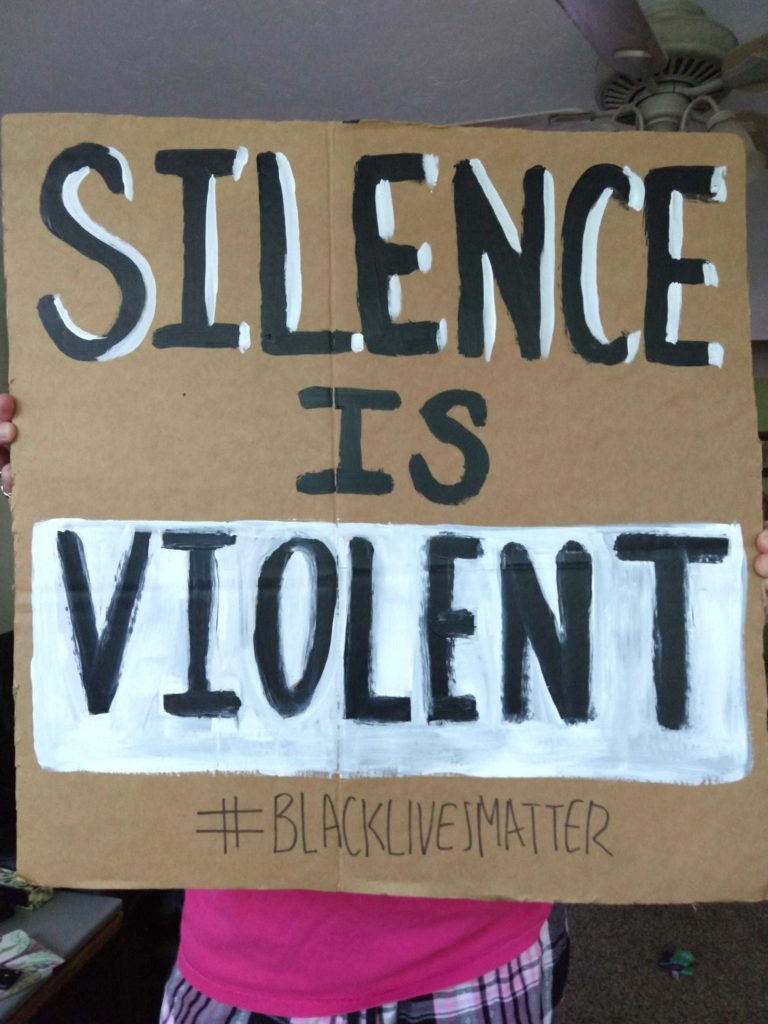 a person holding a cardboard poster for BLM