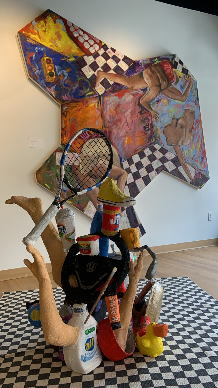 A statue of multiple objects glued together and an abstract painting