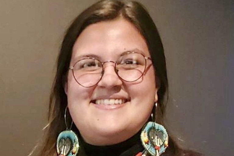 Close-up photo of person with large beaded earrings.