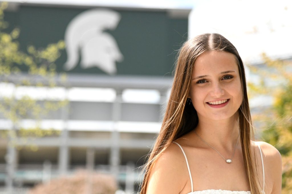 A portrait of Emma Riddering standing in front of Spartan Stadium.