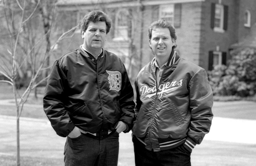 Photo of Jim Cash wearing a Detroit Tigers jacket and Jack Epps Jr. wearing a Dodgers coat.