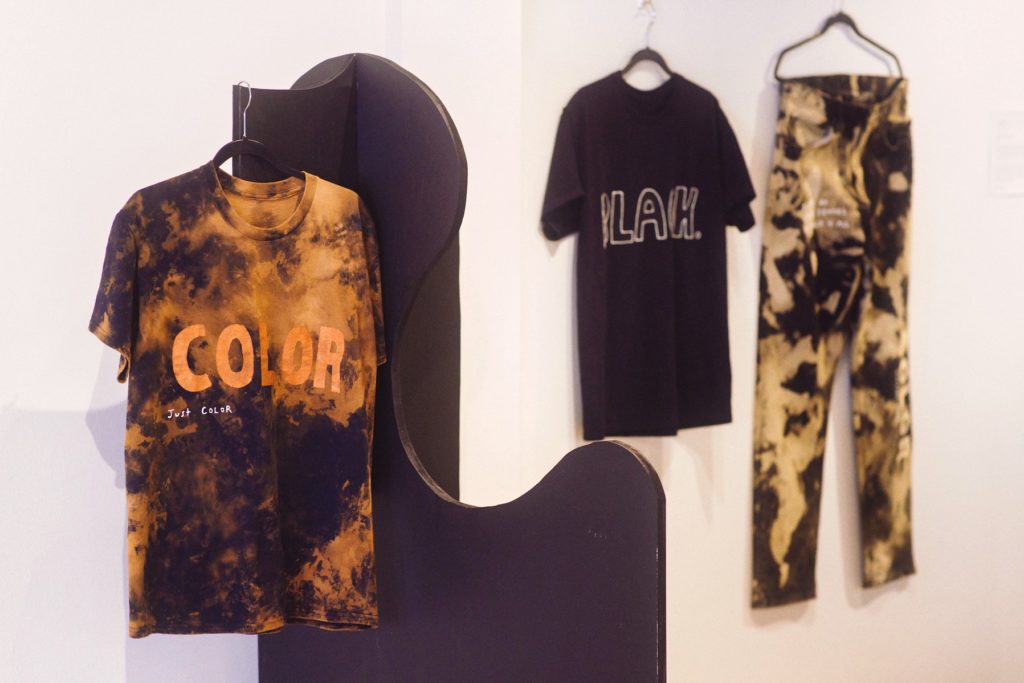 Photo of Bleached clothing with messages like "COLOR, Just Color" and "BLACK."