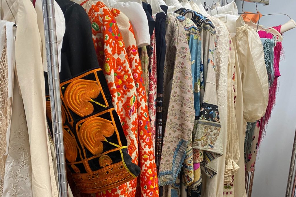 Colorful clothing lined up on a clothing rack.
