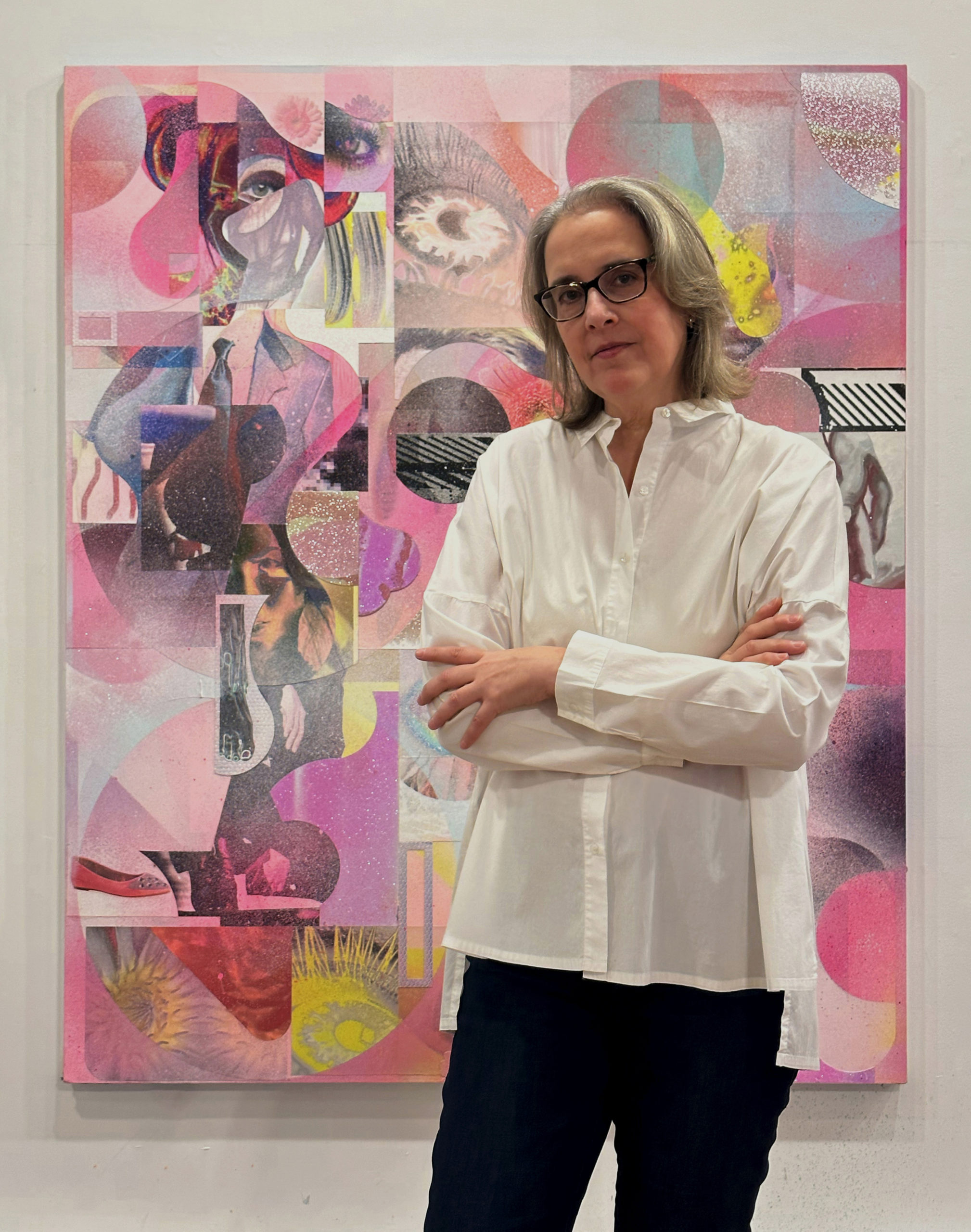 A picture of a woman in a white shirt standing in front of an abstract painting.