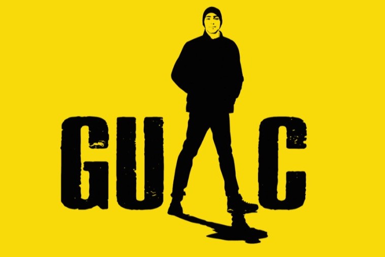 Poster for the one-man show "GUAC" it has a bright yellow background with the word Guac, with a black image of a man in all black with a black hat.