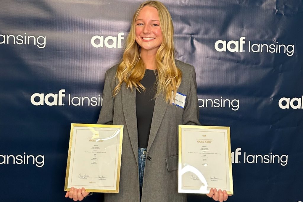 Hope Bennethum holding her two Gold ADDY Awards. 