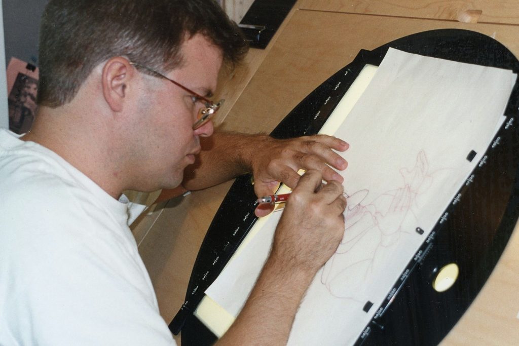A picture of a man in a white shirt with glasses drawing. 