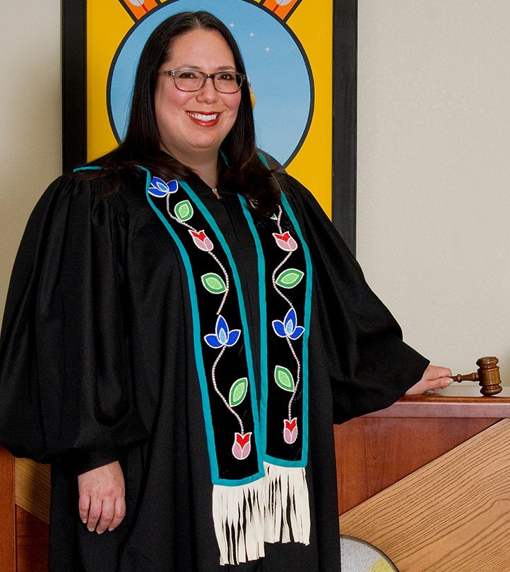 A picture of a woman with glasses and long black hair in a judge robes holding a gavel.