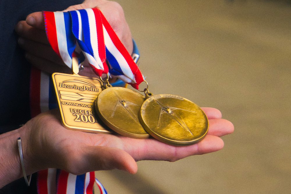 Kelly Salchow MacArthur, a two-time Olympic rower and graphic design professor at Michigan State University, holds three medals from her time as an elite athlete in rowing.