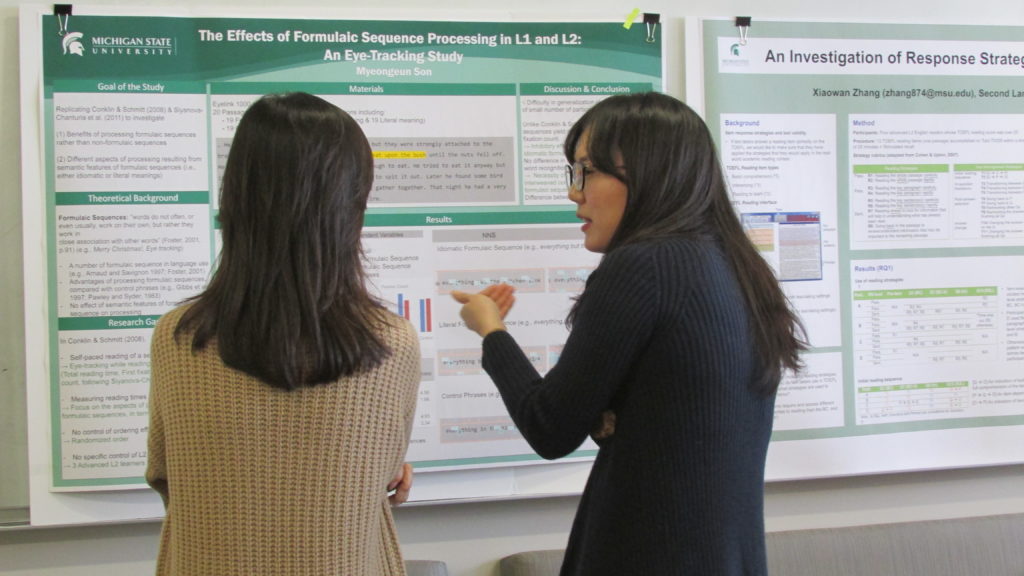 Two Eye Tracking Lab students discussing a poster.